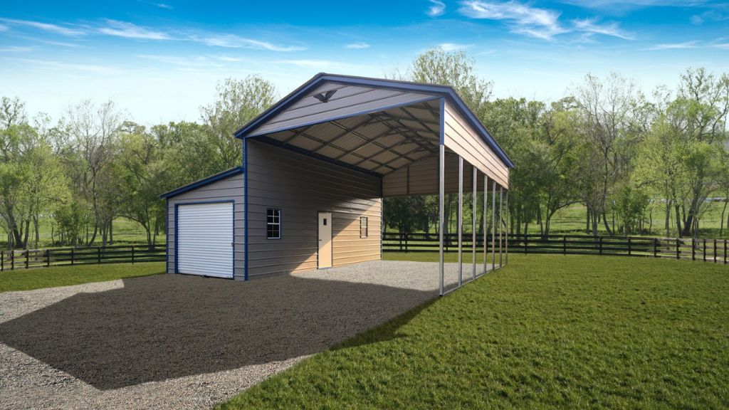 The 28x30x13/8 Vertical Roof Metal Carport with a 10' Wide Lean-To has an open-sided carport and a garage door on gravel, surrounded by lush greenery and trees beneath a bright blue sky.