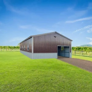 A 24X45X12 Vertical Roof Metal Garage standing alone in the middle of a field.