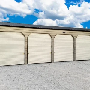 A 24X60X12 Vertical Roof Metal Garage with four doors and a gravel driveway. This 24X60X12 Vertical Roof Metal Garage is equipped with four doors and sits on a spacious gravel driveway.
