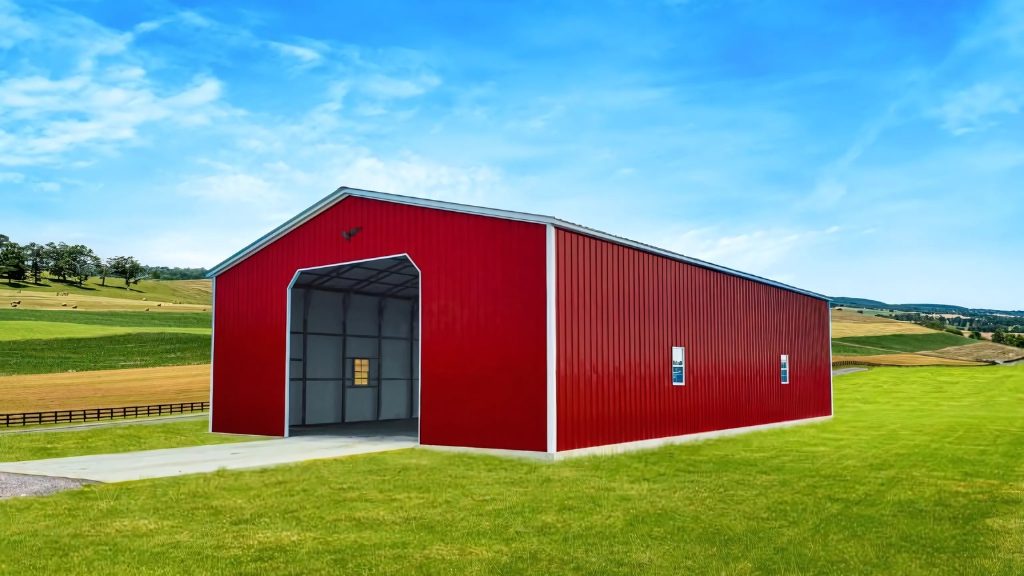 A large red metal barn, echoing the 40x60x12 Vertical Roof Commercial Metal Building, stands proudly on a green grassy field under a clear blue sky.