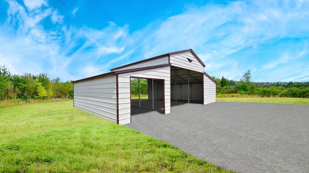 A 44x30x12/7 Vertical Roof Metal Barn With a 12' Wide Lean-To stands on gravel with open doors, set in a lush grassy field under a blue sky with wispy clouds.