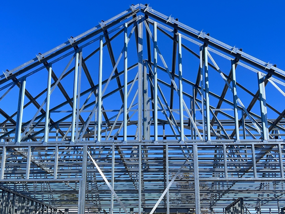 A cost-effective metal building under construction with a blue sky.