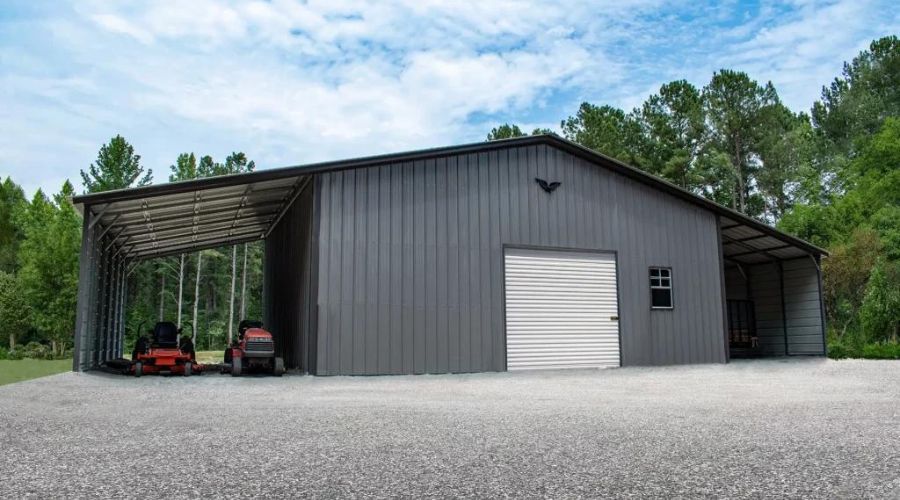 A large metal building with an open side sheltering two tractors, a roll-up door, and surrounded by trees under a partly cloudy sky offers ample space. To maintain optimal conditions inside, the cheapest way to insulate a metal building can be considered for better energy efficiency.